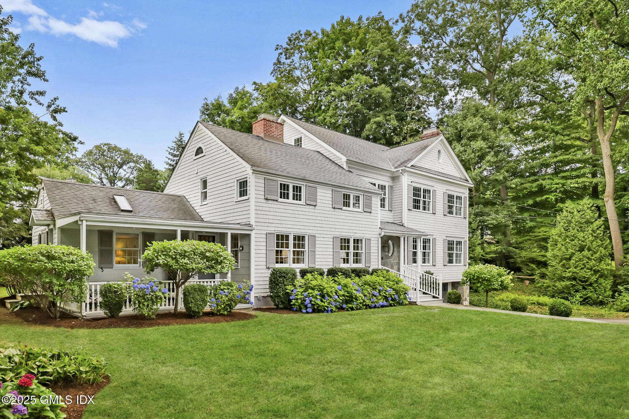 a front view of a house with a yard and green space