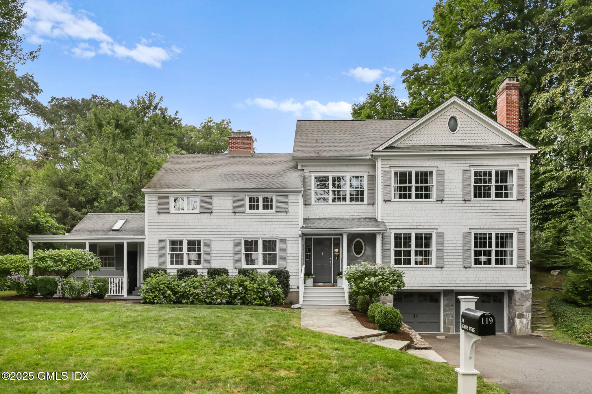 119 Hendrie Avenue Riverside, CT 06878 - Photo 7 of 7 a front view of a house with a yard and potted plants
