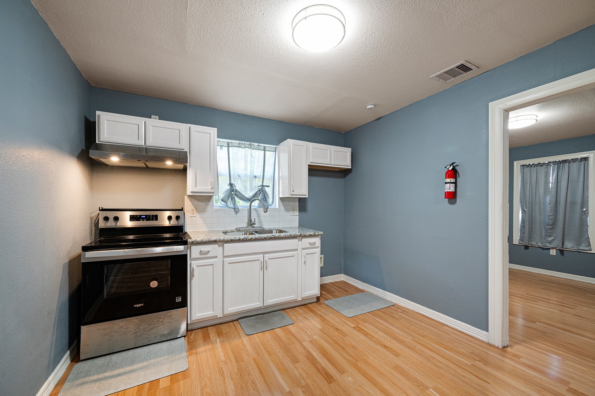 7815 Harding Street, Unit B Houston, TX 77012 - Photo 15 of 21 This charming kitchen boasts sleek stainless steel appliances, pristine white cabinetry, and warm flooring, creating a bright and welcoming culinary space.