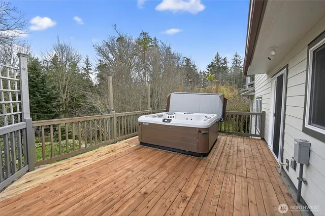 a view of a roof deck with wooden floor and fence with a bench