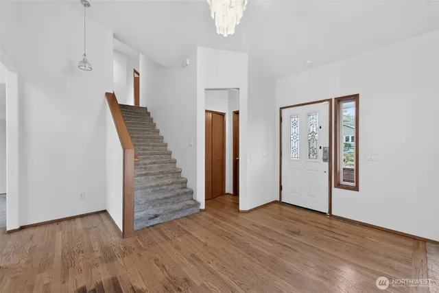 an empty room with wooden floor and entryway