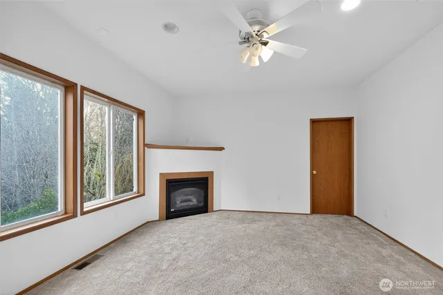 a view of empty room with fireplace and fan