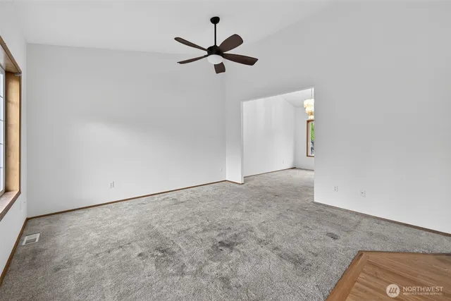 an empty room with a ceiling fan and window