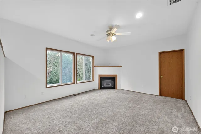 a view of empty room with a fireplace and fan