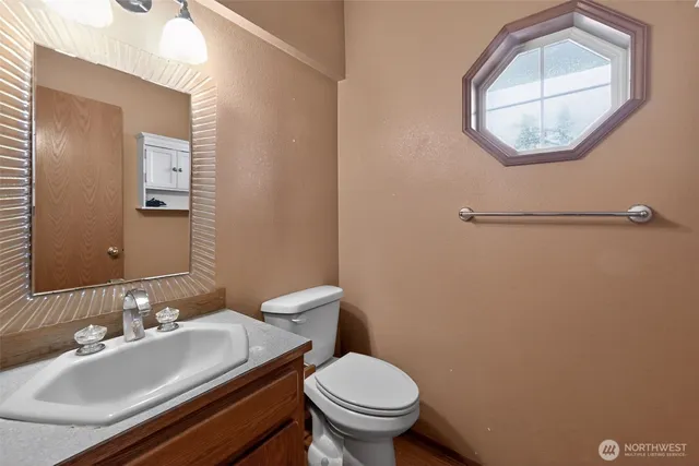 a bathroom with a sink mirror and toilet