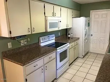 a kitchen with granite countertop a cabinets and a stove top oven
