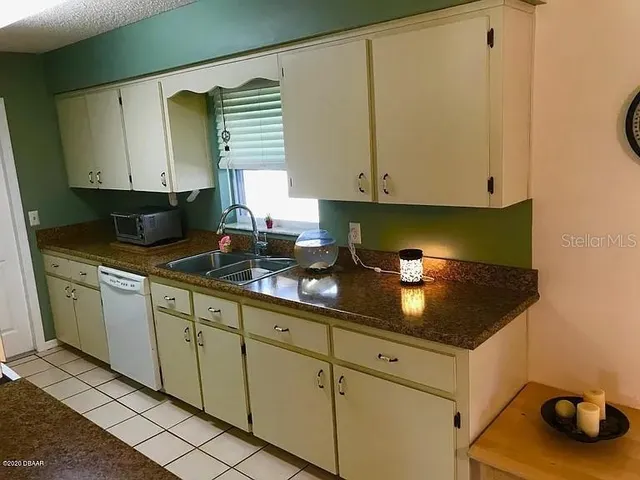 a kitchen with granite countertop a sink a stove and cabinets