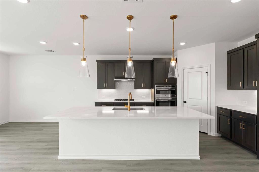 1304 Abbott Crk Road Celina, TX 75009 - Photo 12 of 29 a kitchen with kitchen island a counter top space appliances and cabinets
