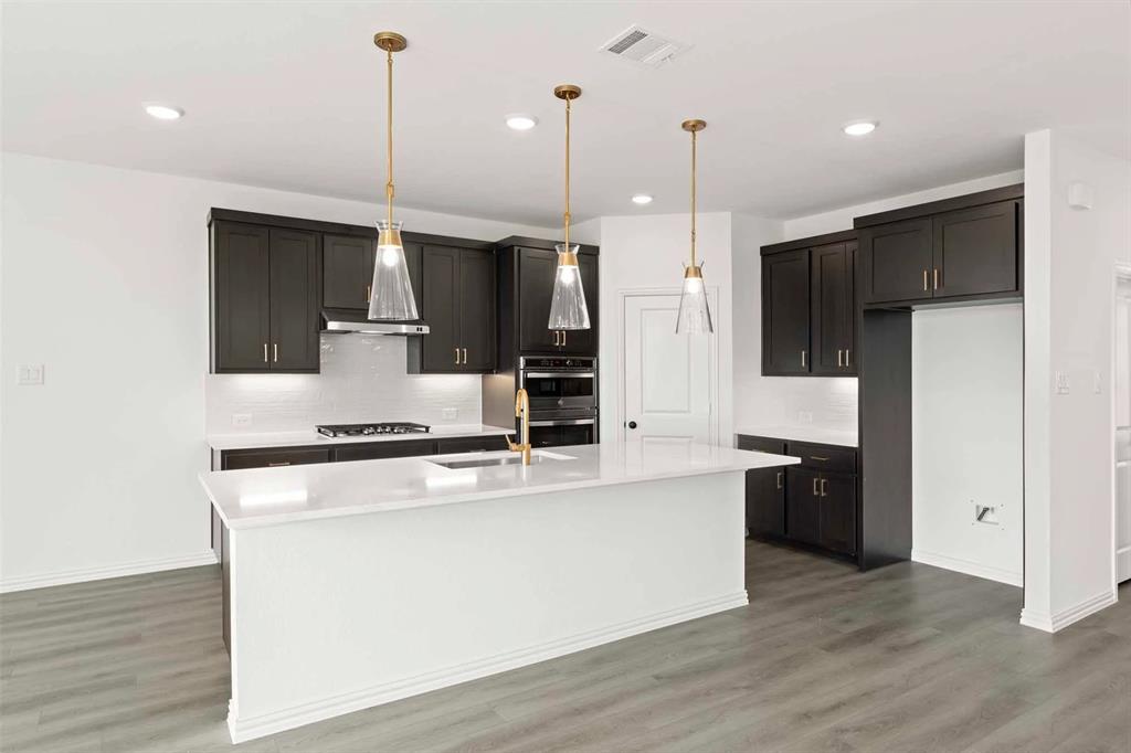 1304 Abbott Crk Road Celina, TX 75009 - Photo 13 of 29 a large kitchen with stainless steel appliances kitchen island a large counter top space wooden floor and a view of kitchen