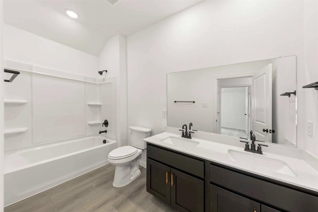 1304 Abbott Crk Road Celina, TX 75009 - Photo 23 of 29 a bathroom with a double vanity sink toilet mirror and bathtub