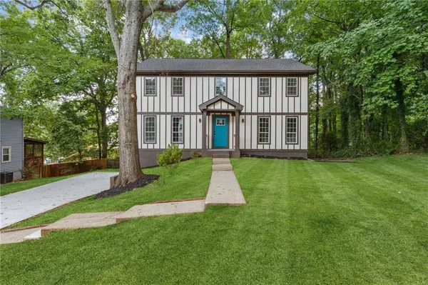 a front view of a house with a yard and trees