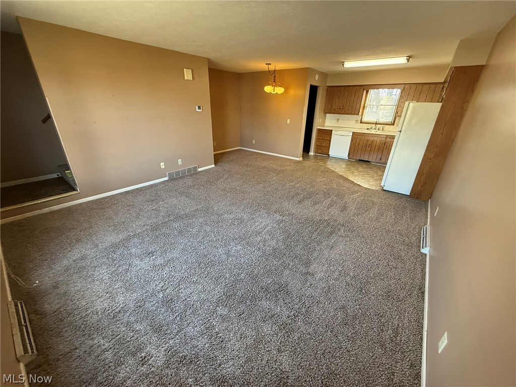 604 Harger Street Dover, OH 44622 - Photo 3 of 25 Unfurnished living room with baseboards and light carpet