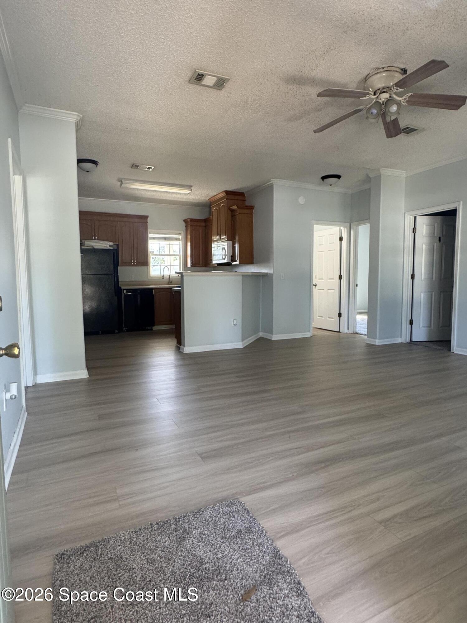 1130 Grapefruit Road Southeast Palm Bay, FL 32909 - Photo 3 of 14 a view of a living room a kitchen and a wooden floor