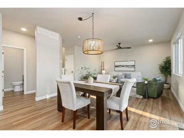 a dining room with furniture a chandelier and wooden floor