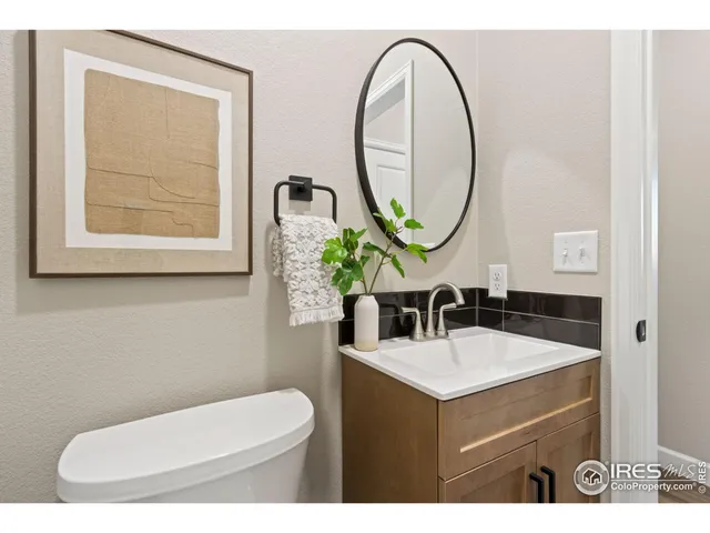 a bathroom with a toilet sink mirror and vanity