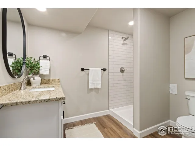 a bathroom with a granite countertop sink a toilet and shower