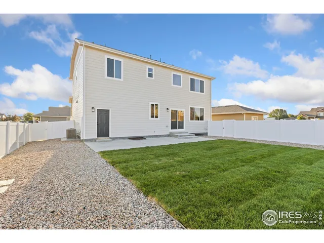 a view of a backyard with plants and a bench