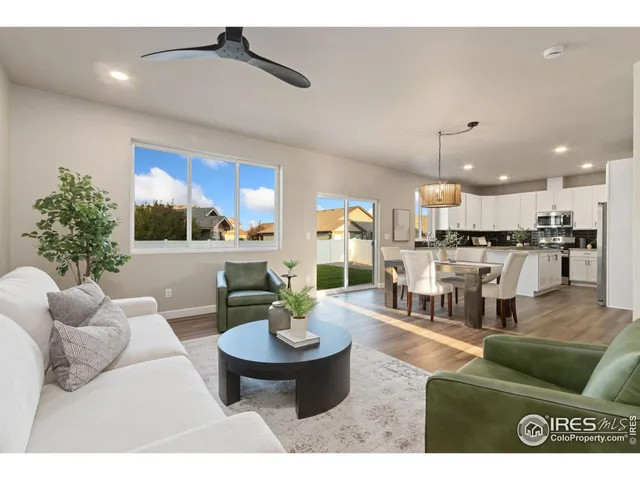 a living room with furniture and a view of kitchen