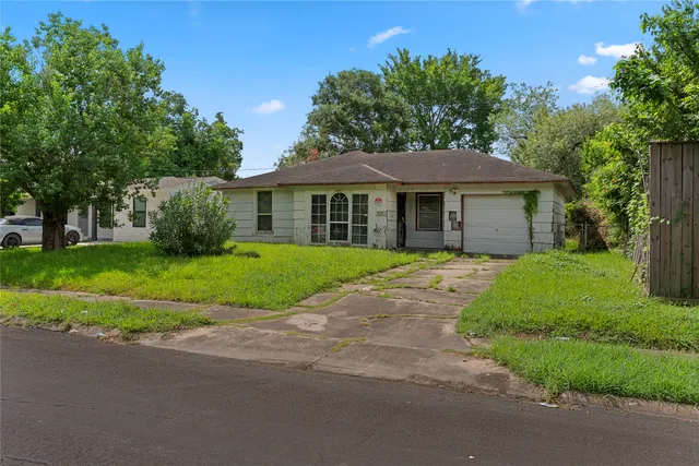 a front view of a house with a yard and potted plants
