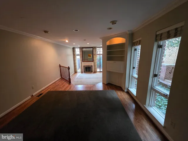 a view of a hallway with wooden floor and a glass door