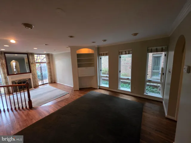a view of an empty room with window and wooden floor
