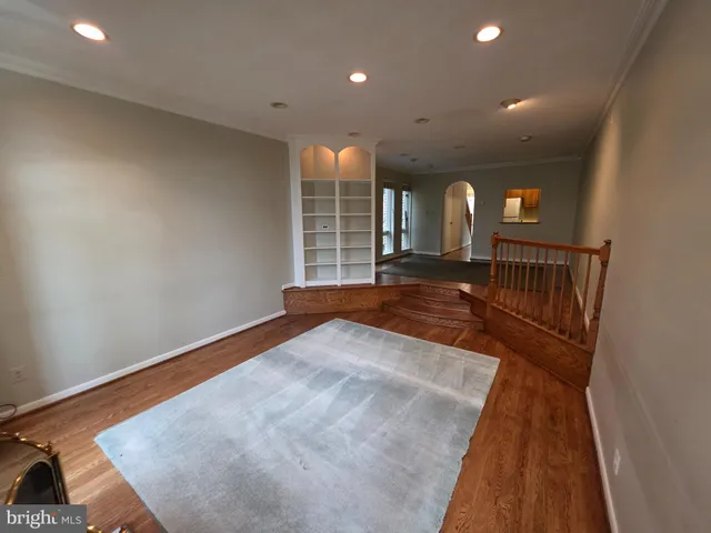 a view of hallway with stairs and wooden floor