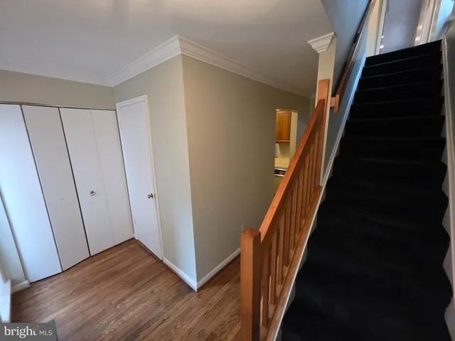 a view of a hallway with wooden floor and entryway