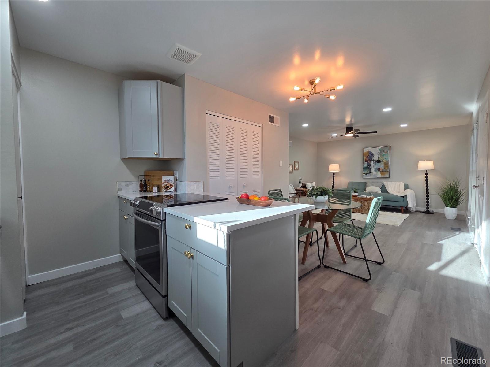 1250 South Monaco Parkway, Unit 17 Denver, CO 80224 - Photo 1 of 29 a kitchen that has a lot of cabinets in it and wooden floors