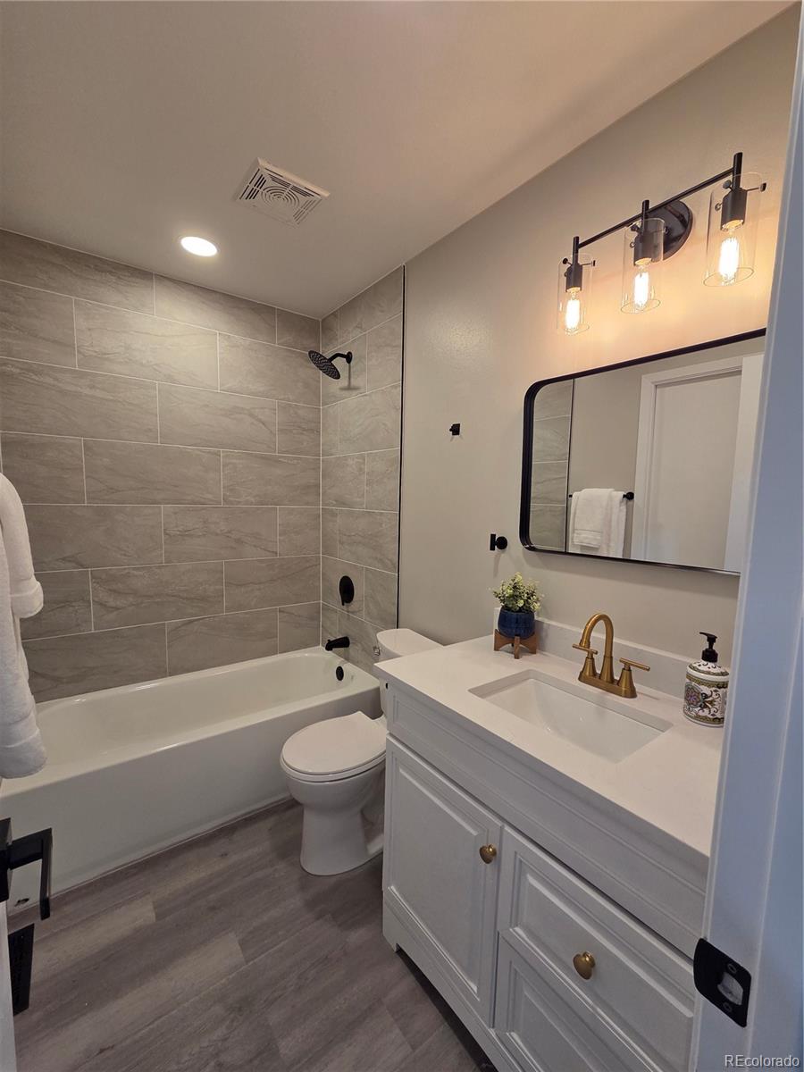 1250 South Monaco Parkway, Unit 17 Denver, CO 80224 - Photo 14 of 29 a bathroom with a toilet a sink a tub and mirror