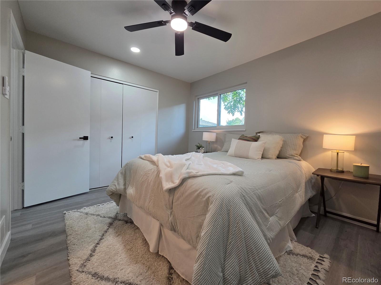 1250 South Monaco Parkway, Unit 17 Denver, CO 80224 - Photo 18 of 29 a spacious bedroom with a bed and a chandelier
