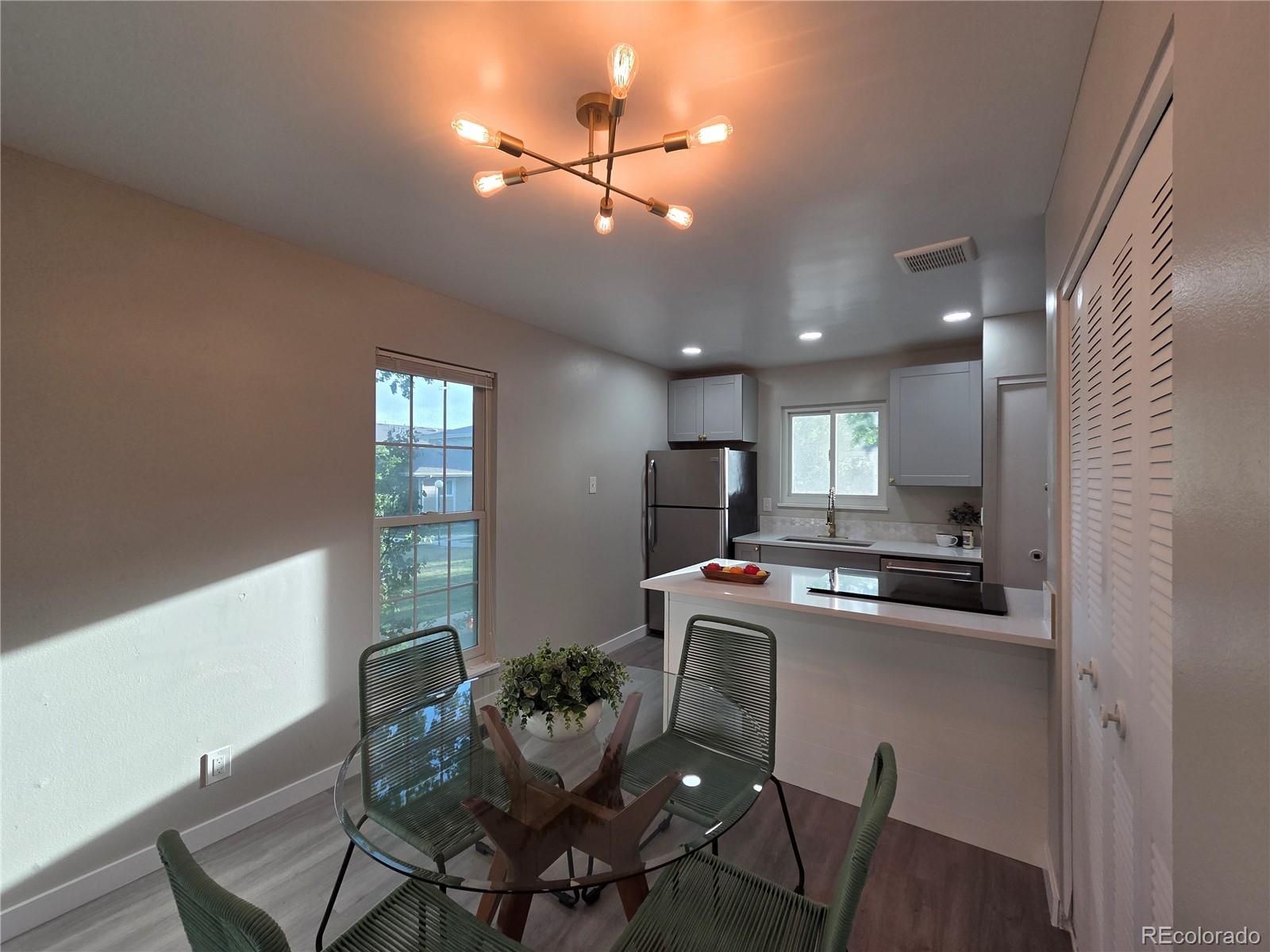 1250 South Monaco Parkway, Unit 17 Denver, CO 80224 - Photo 7 of 29 a kitchen with a dining table chairs and refrigerator