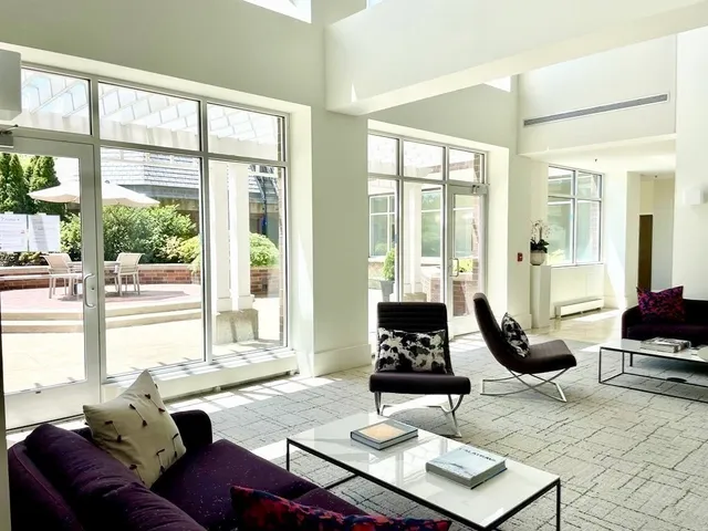 a living room with furniture and floor to ceiling windows
