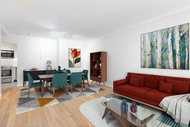a living room with furniture kitchen view and a window