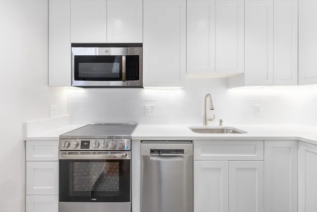 a kitchen with a stove and a white cabinet