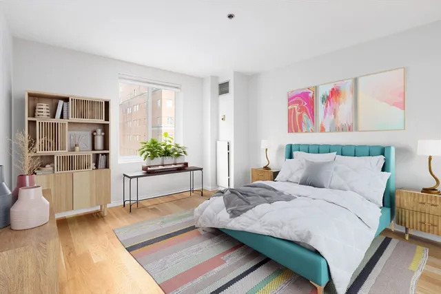 a spacious bedroom with a bed and a potted plant