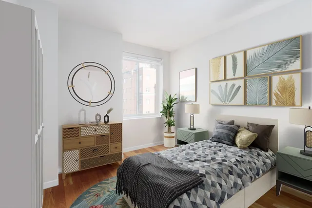 a bedroom with a bed a mirror on dresser and a window