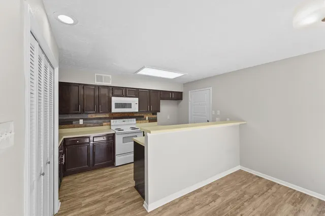 a kitchen with kitchen island a sink cabinets and stainless steel appliances