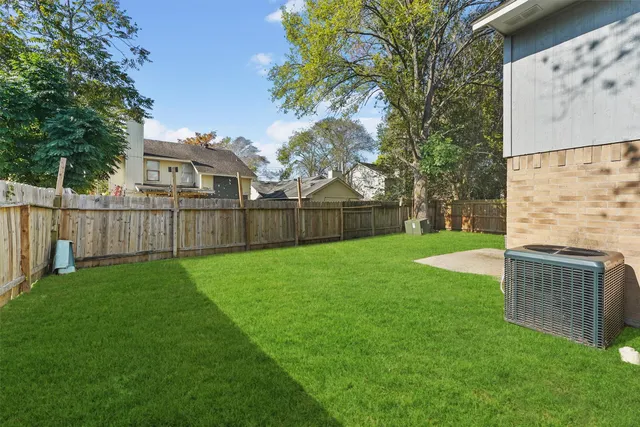 a view of a house with backyard and a tree