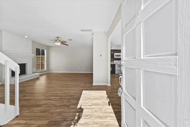 a view of a hallway with wooden floor and staircase