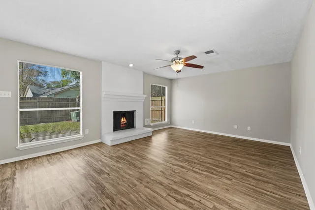an empty room with wooden floor and fireplace