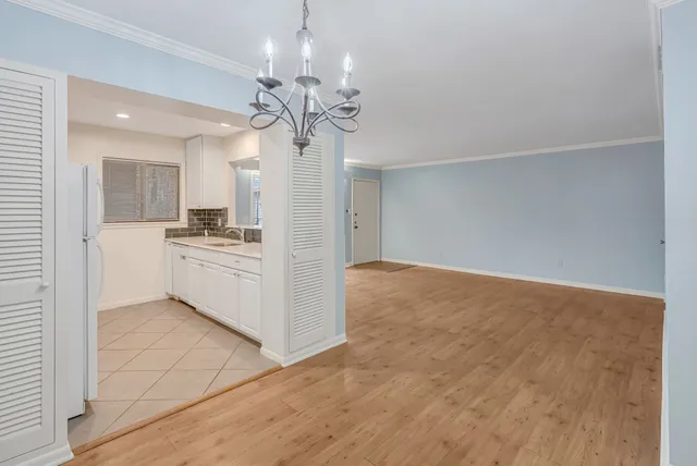 a view of a kitchen with a sink a stove top oven and chandelier