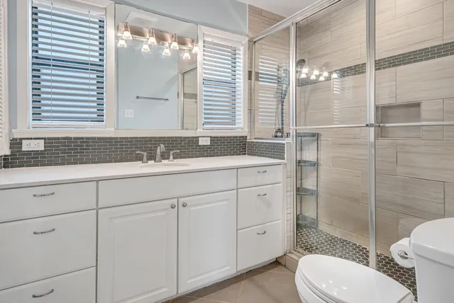 a bathroom with a sink a toilet and shower