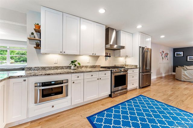 a kitchen with stainless steel appliances granite countertop a stove a sink and a refrigerator