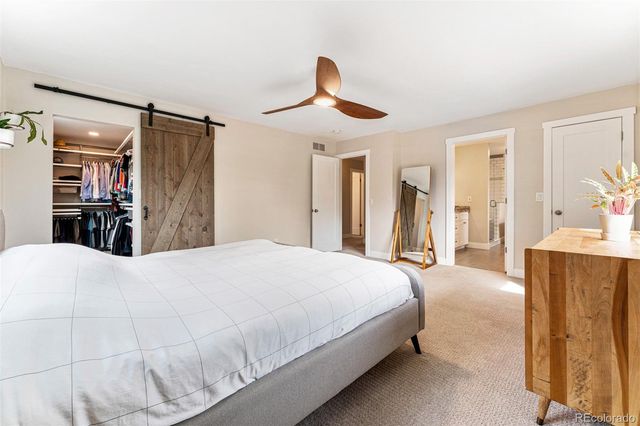 a spacious bedroom with a bed and a large mirror