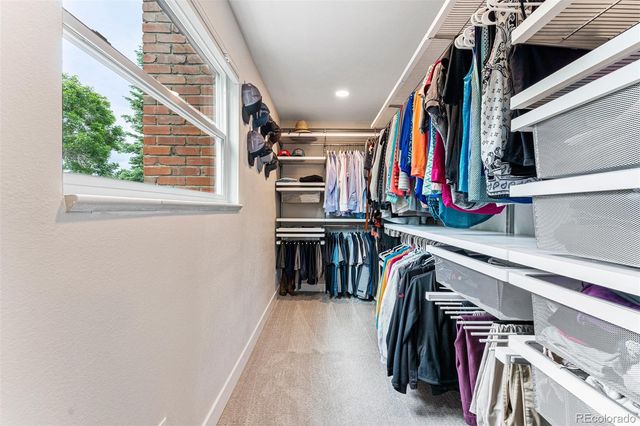 a view of walk in closet with clothes and shoes