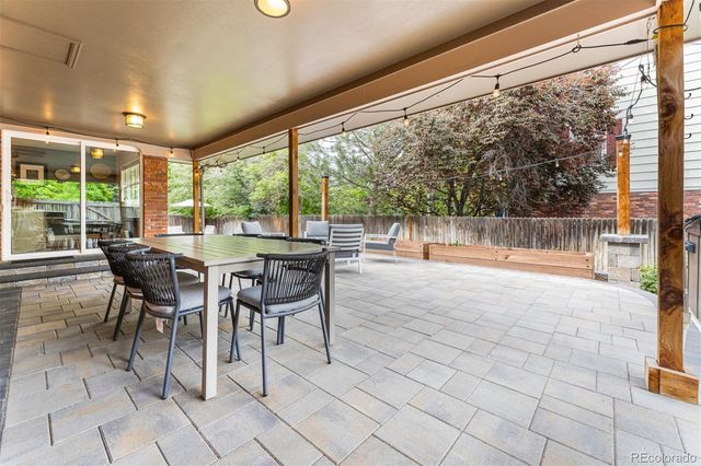 a dining room with furniture and large windows