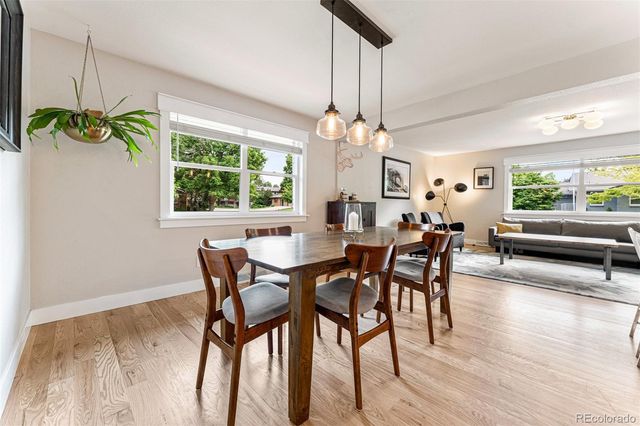 a view of a dining room with furniture a chandelier and wooden floor