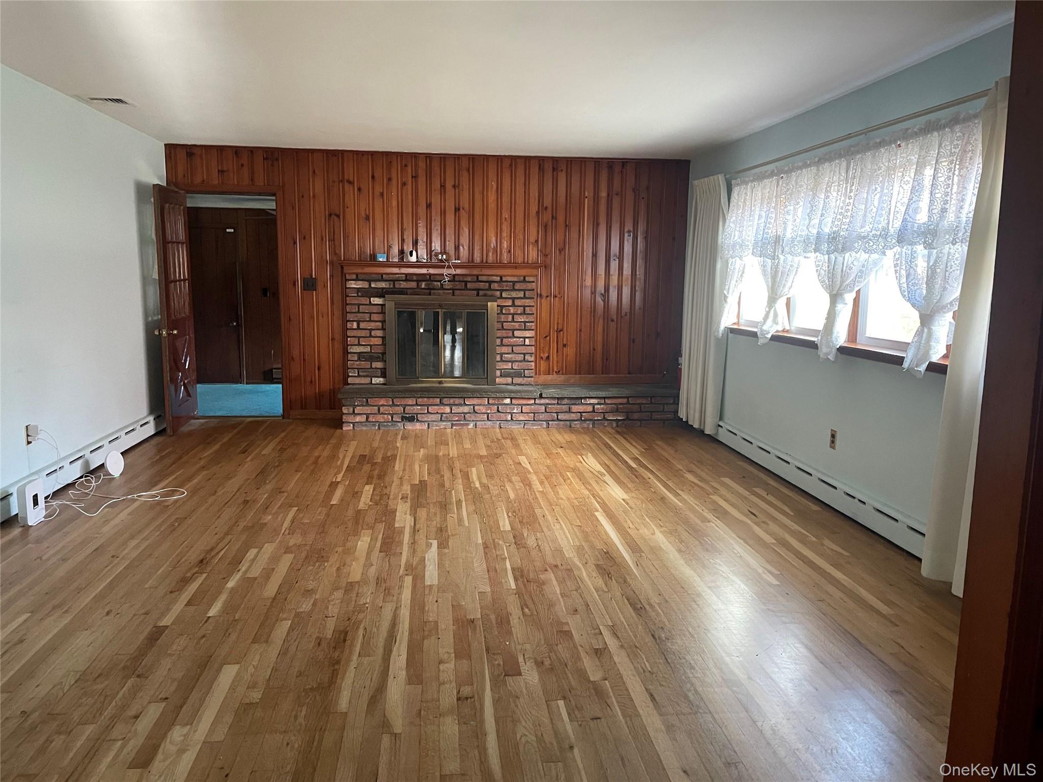 8 Atlantic Avenue Blue Point, NY 11715 - Photo 14 of 24 an empty room with wooden floor fireplace and windows