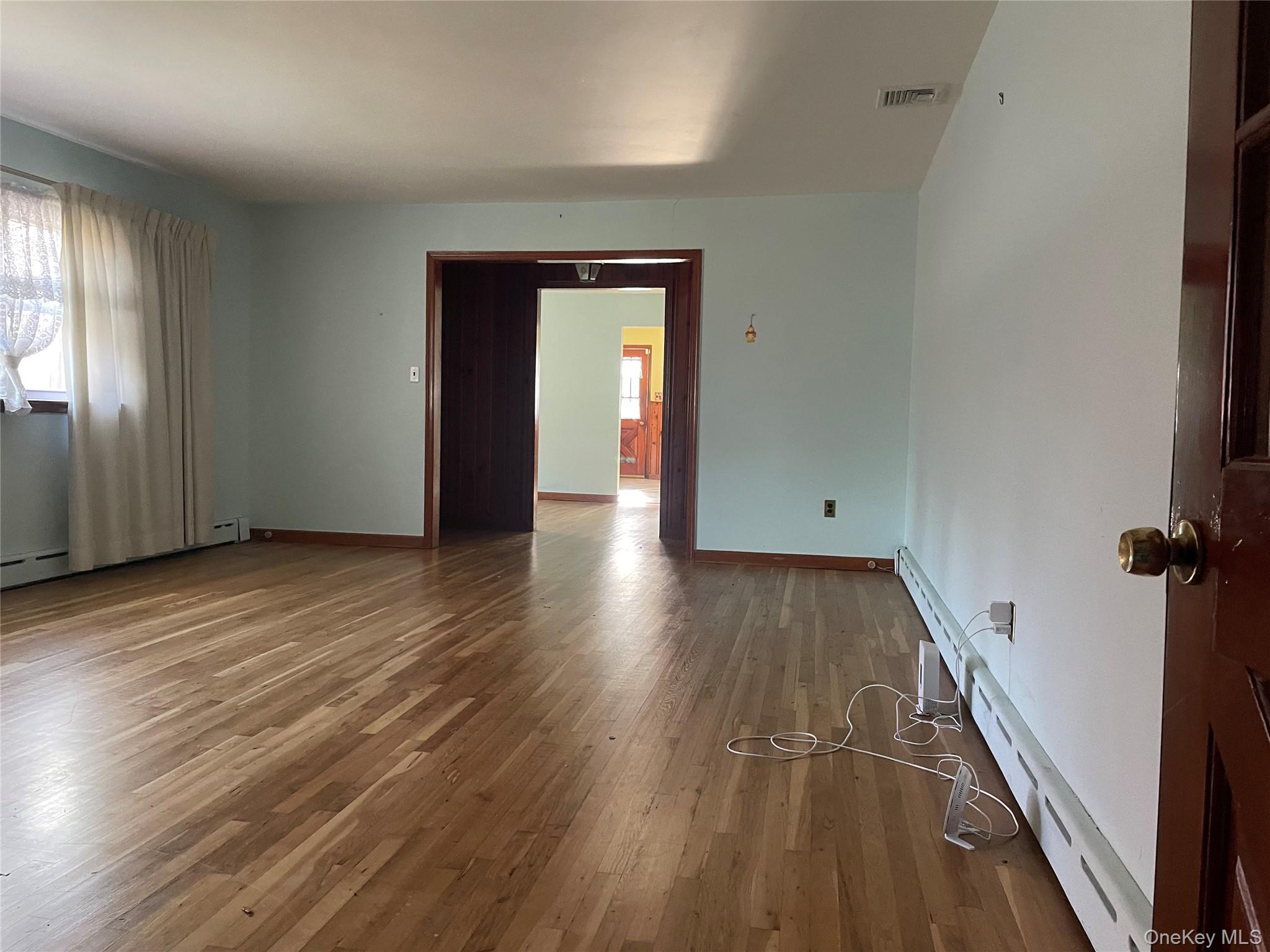 8 Atlantic Avenue Blue Point, NY 11715 - Photo 21 of 24 an empty room with wooden floor and windows