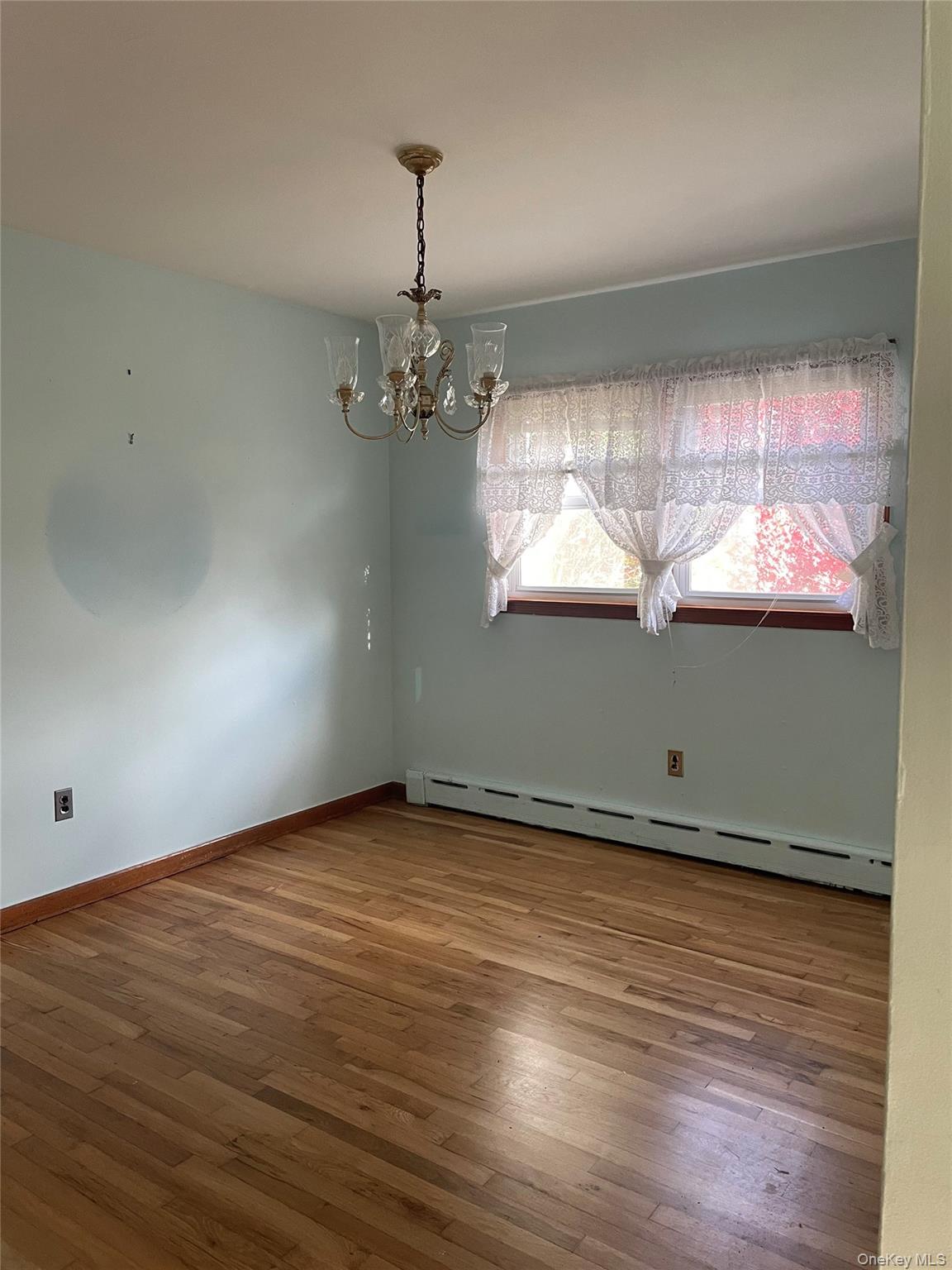 8 Atlantic Avenue Blue Point, NY 11715 - Photo 8 of 24 an empty room with wooden floor wooden floor and chandelier